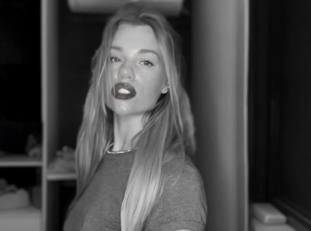 Replace the woman in the video with the person from @image1. Take her face exactly from @image1: facial features, face shape, nose, lips, eye shape, eye color a…