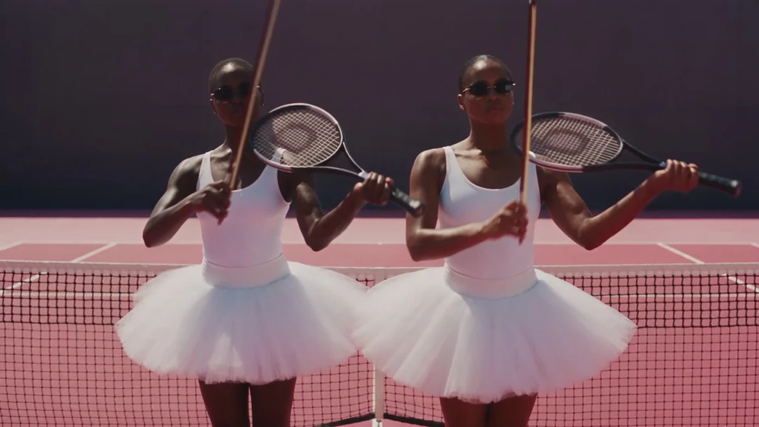 References @Image1 — user-uploaded face photo. Applies ONLY to the lead ballerina who dances alone in the centre of the court. Use for identity only: exact face…